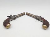 a pair of old revolvers sitting on top of each other