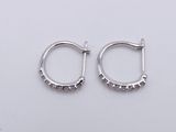 pair of silver hoop earrings with small beads on a white background