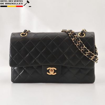 un sac Chanel noir avec des finitions dorées et une chaîne