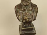 bronze bust of a man with a beard and a hat