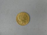 a close up of a gold coin on a white surface