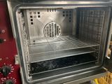 a red oven with a metal rack in it