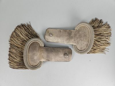 une paire de vieilles brosses en bois posées sur une surface blanche