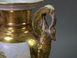 a gold and white vase with a bird on it