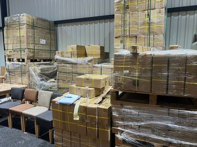 many chairs and tables in a warehouse with boxes on the floor