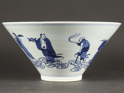 a blue and white bowl with a man and a bird on it