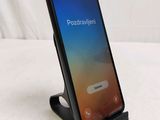 an image of a black phone on a stand on a white surface