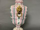 a large vase with a lion head on the top of it