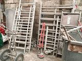a pile of chairs and a cart in a garage