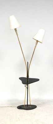 une table noire sur laquelle sont posées trois lampes, avec un mur blanc en arrière-plan