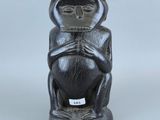 un gros plan d'une statue représentant un singe sur fond blanc
