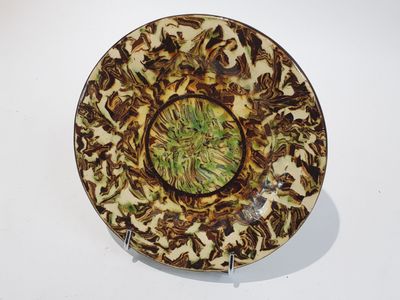 une assiette marron et verte posée sur une table blanche