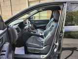 the interior of a car with the door open and the driver ' s seat down