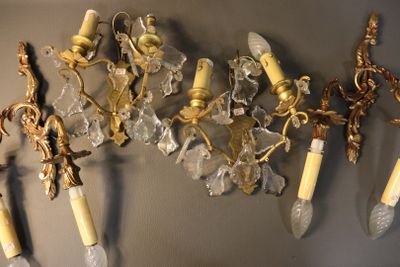 five wall sconces hanging on the wall next to each other