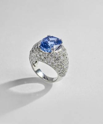 a blue sapphire and diamond ring on a white surface