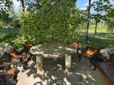 a stone table and benches in a park with trees