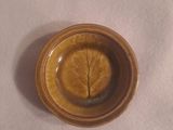 un petit bol contenant une feuille, posé sur une table