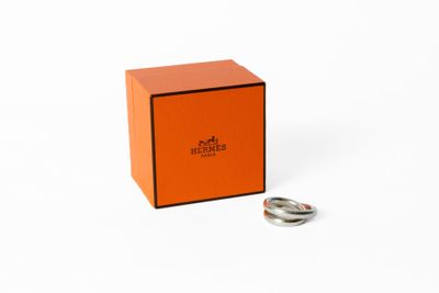 une boîte orange contenant une bague, posée sur une surface blanche