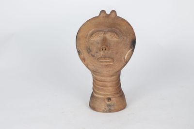 a close up of a wooden object with a face on it