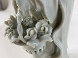 a statue of a woman holding a bunch of flowers