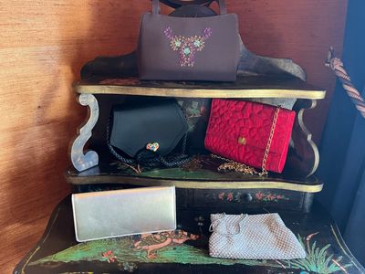 several purses are stacked on top of each other on a shelf