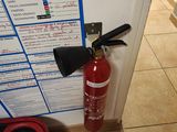 a red fire extinguisher next to a white door