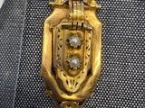 un pendentif en or orné d'une perle au centre