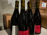 several bottles of wine are lined up on a counter