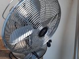 un ventilateur posé sur une table en bois