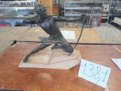 a bronze statue of a man holding a bow and arrow