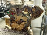 a statue of a dragon made of wood in a workshop