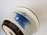 un vase bleu et blanc orné d'une horloge