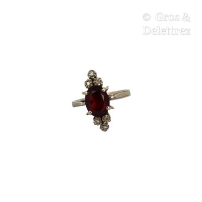 une image d'une bague avec une pierre rouge entourée de diamants blancs