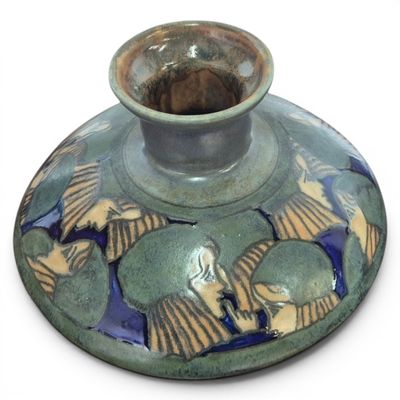 a green vase with a blue and yellow design on it
