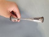 a person holding a spoon in their hand on a table