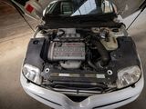 a white car with a engine in the back of it