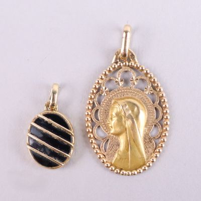 two gold and black pendants of a woman and a man