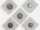 quatre types de pièces différents sont disposés sur une surface blanche
