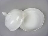 a white bowl with a lid sitting on a table