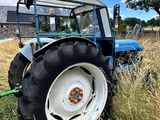 un tracteur bleu garé dans l'herbe