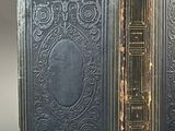 an old book with a black cover and gold trim