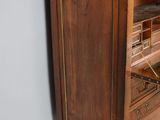 a tall wooden cabinet with drawers and a clock on top