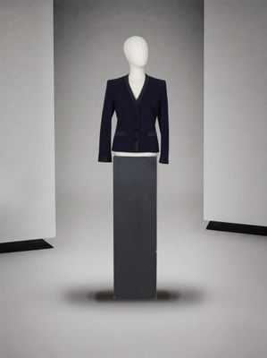 un mannequin au milieu d'un podium, vêtu d'un costume