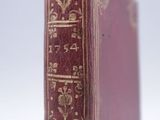 an old book sitting on top of a white surface
