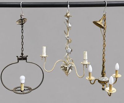 three chandeliers hanging from a metal pole with candles on them
