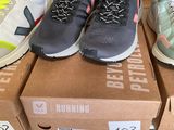several pairs of running shoes sitting on top of boxes in a store