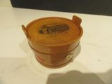 un seau en bois posé sur une table, muni d'un couvercle