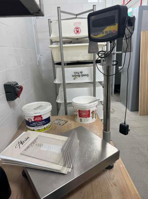 une photo d'une balance de cuisine à côté d'un seau de peinture