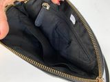 someone is holding a black purse with gold zippers on it