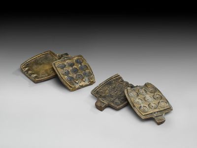 deux boucles de ceinture en bronze, dont l'une est ornée de fleurs et de feuilles